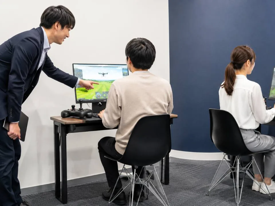 ドローンシミュレータで基本操作を練習する受講者